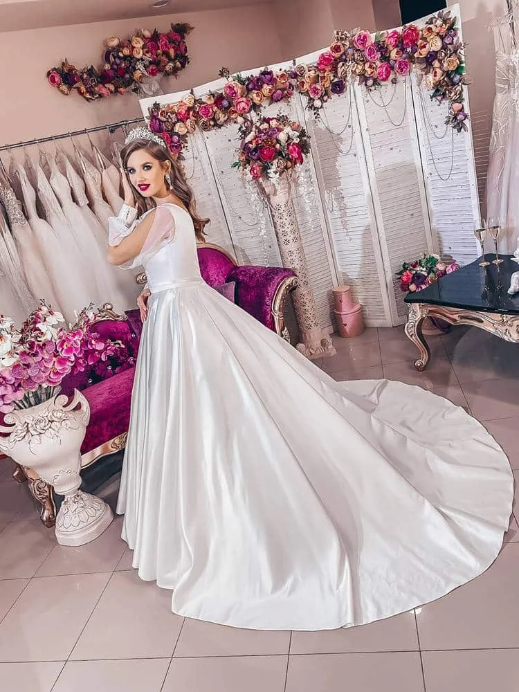 ---Refined dress with a romantic allure, in precious satin fabric, with feminine long sleeves in organza and a chapel train on t